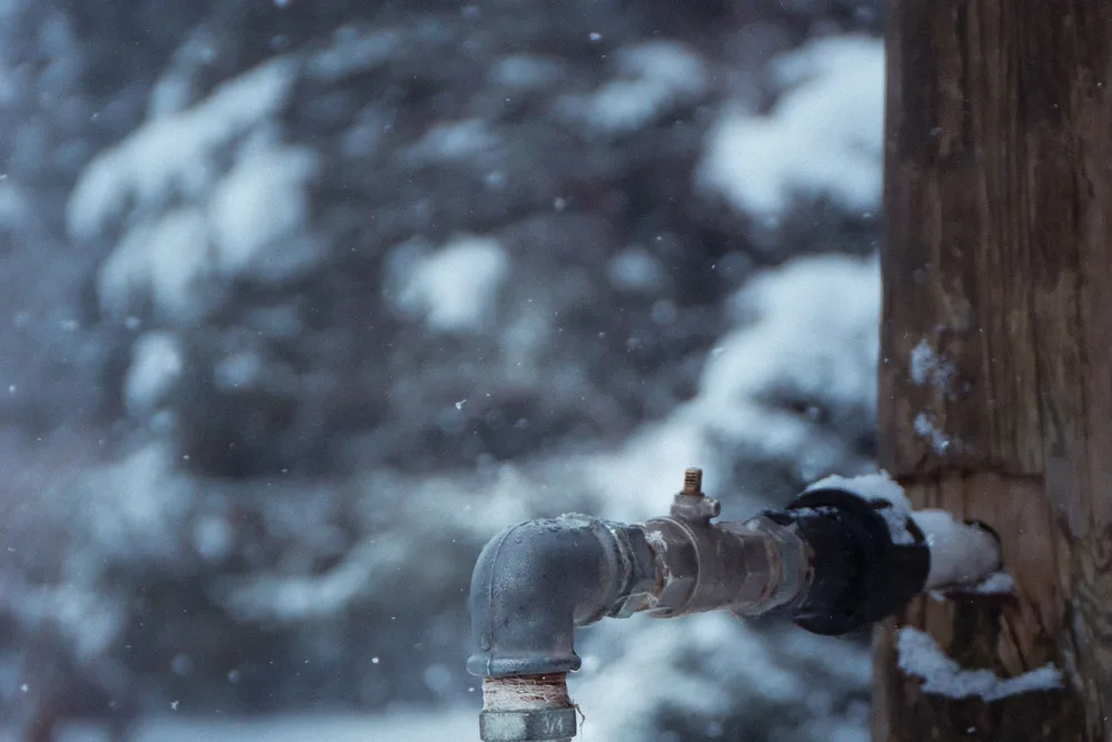 Outdoor water pipe and spigot in freezing winter conditions, at risk of a frozen or burst line