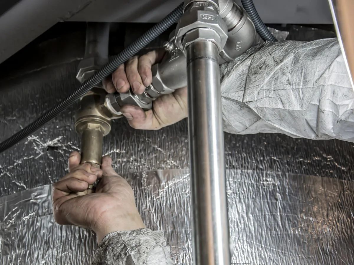 Plumber installing pipe fittings, representing Ventura Plumbing's craftsmanship in Rapid City, SD