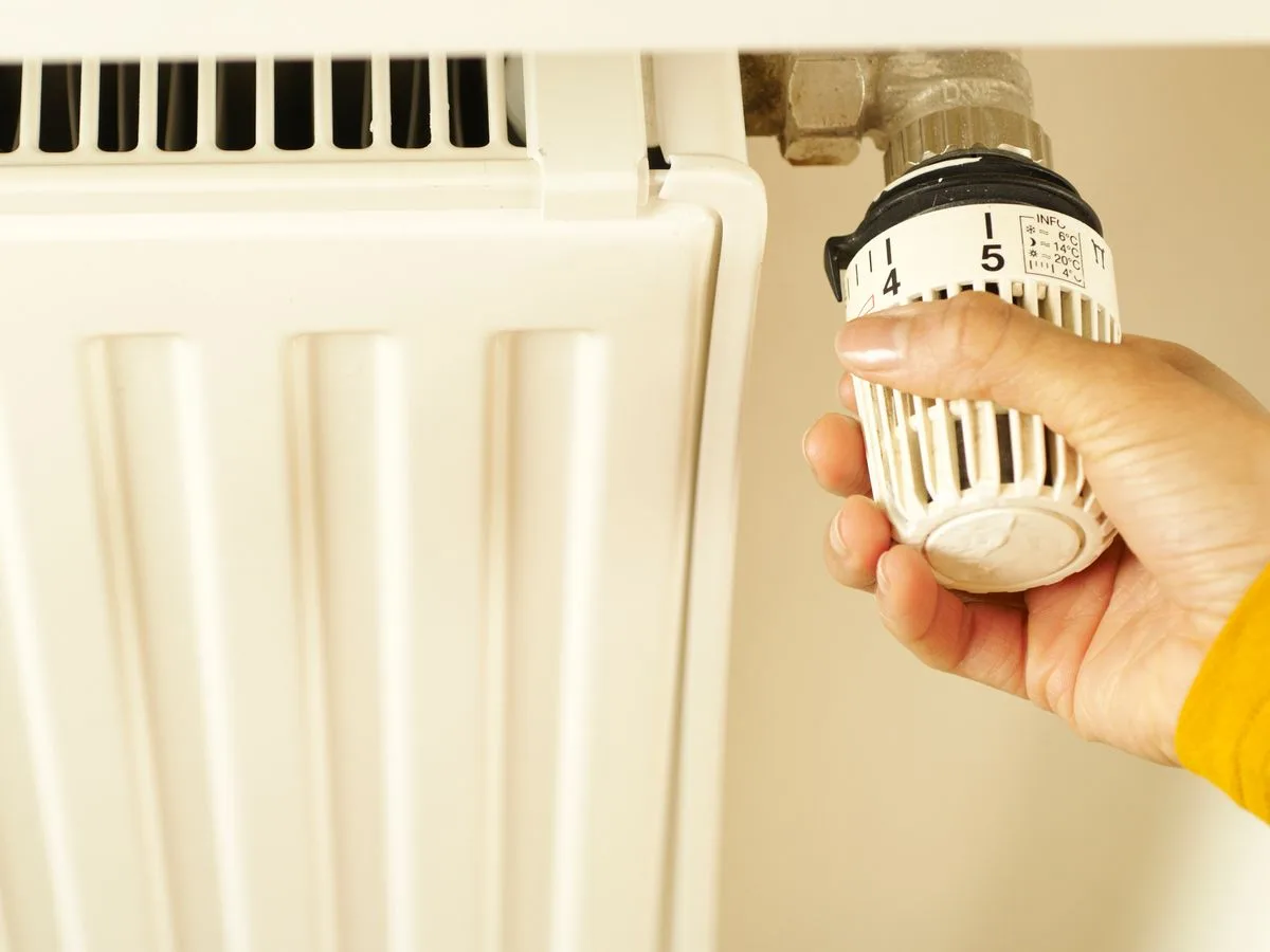 Hand adjusting a heating valve for tankless water heater service in Rapid City, SD