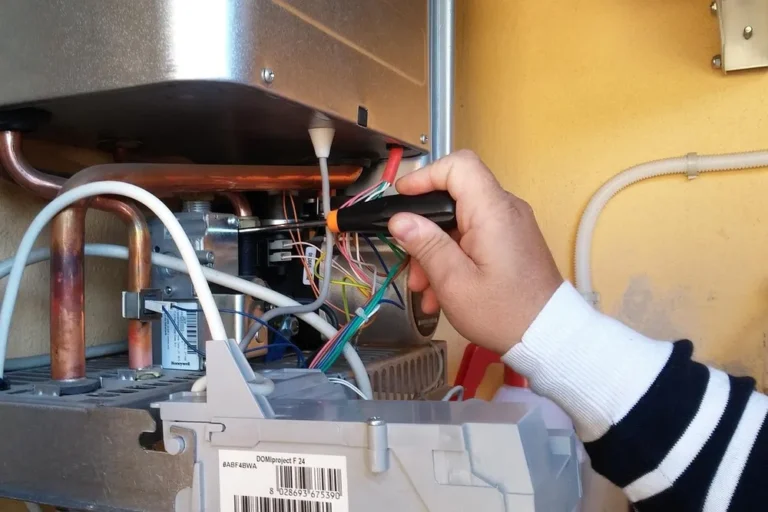 Technician repairing an open residential water heater unit in Rapid City